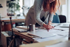 Woman working on scattered paperwork