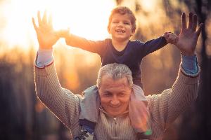 Grandfather with child on shoulders smiling
