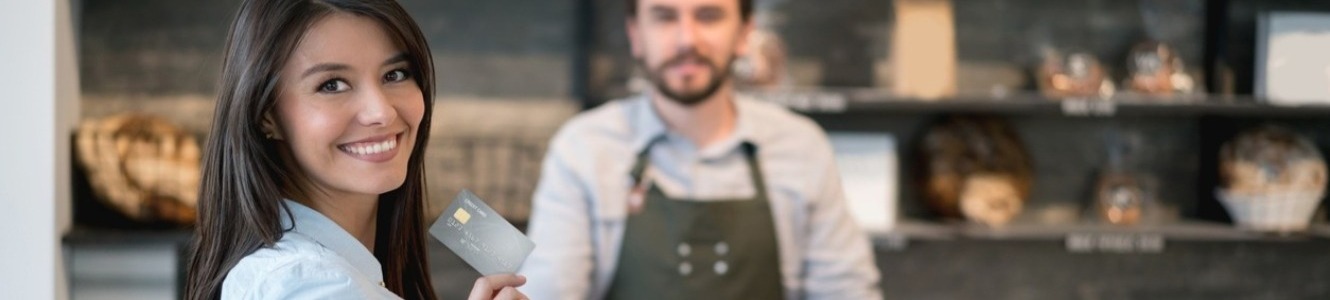 Woman paying with debit card at bakery