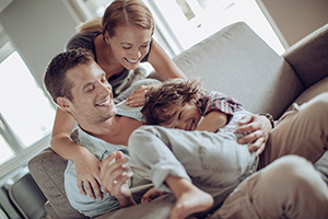 Couple with laughing child on couch