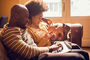 Couple at home on laptop sitting on couch