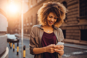 Woman on city sidewalk using cellphone
