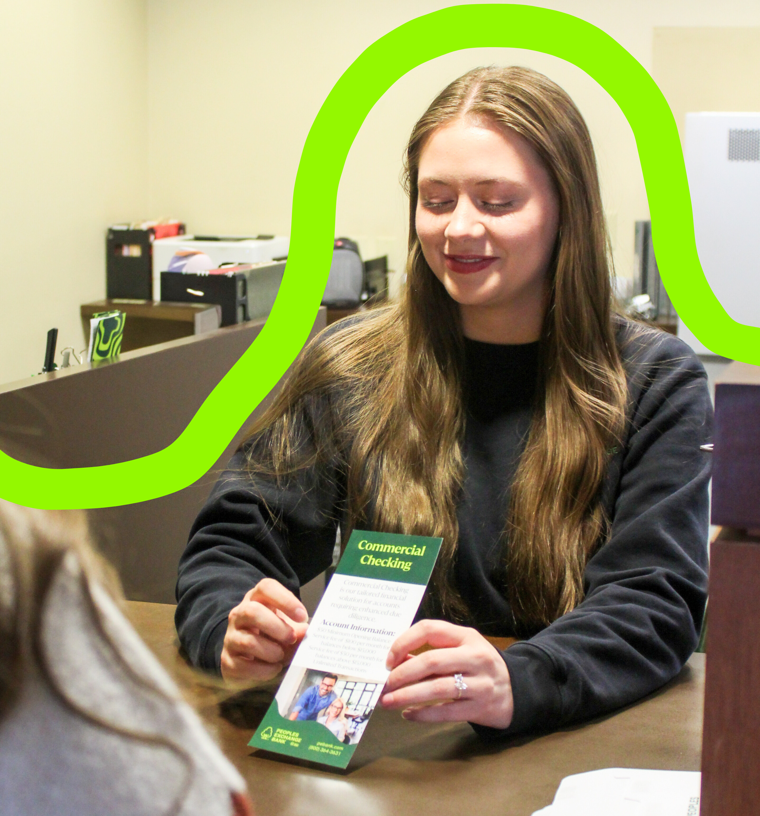 PEB employee discussing commercial checking accounts brochure with a customer