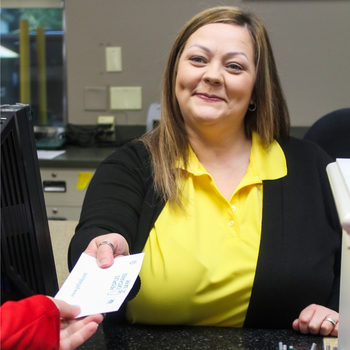 PEB employee handing a customer a money envelope