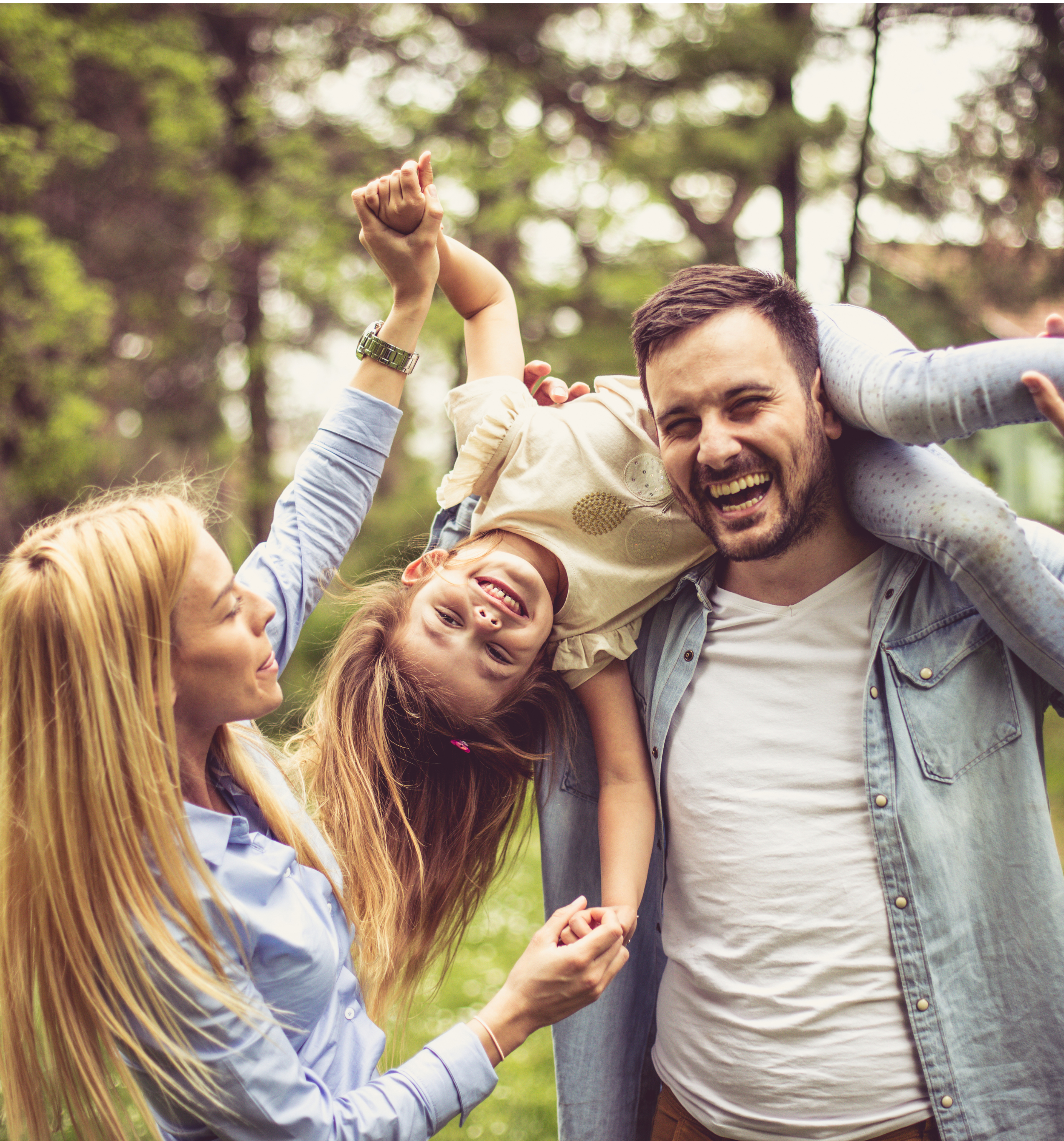Family smiling together outside while playing