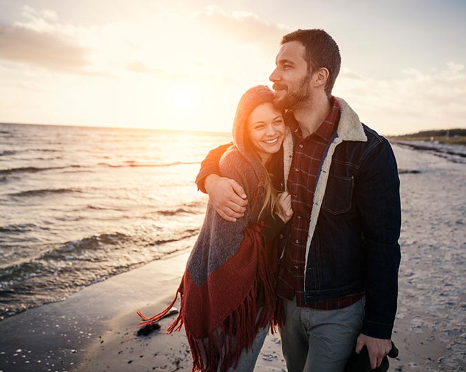 Couple embracing each other while walking on the beach 