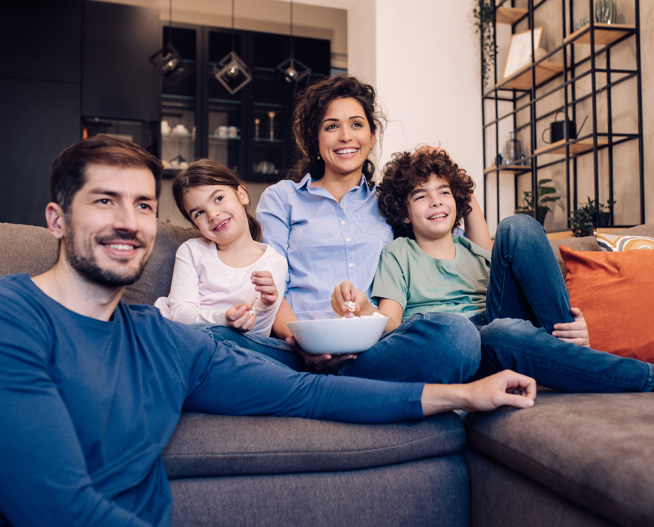 Family enjoying a movie together while eating popcorn