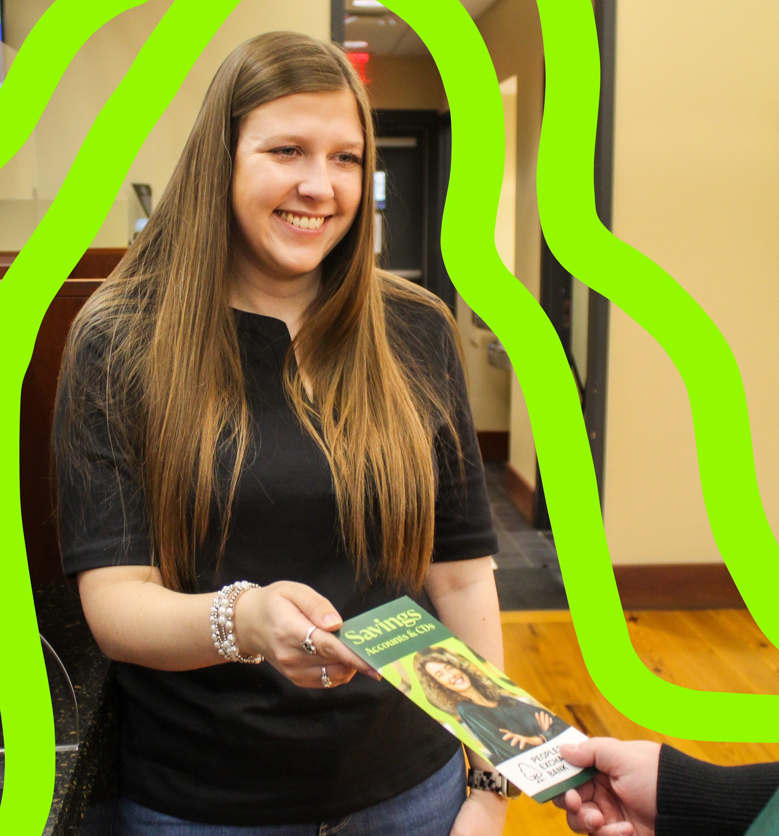 Peoples Exchange Bank employee smiling while handing a client a Savings Account brochure