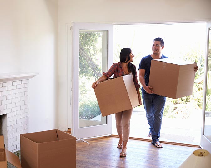 Couple moving boxes into their new home