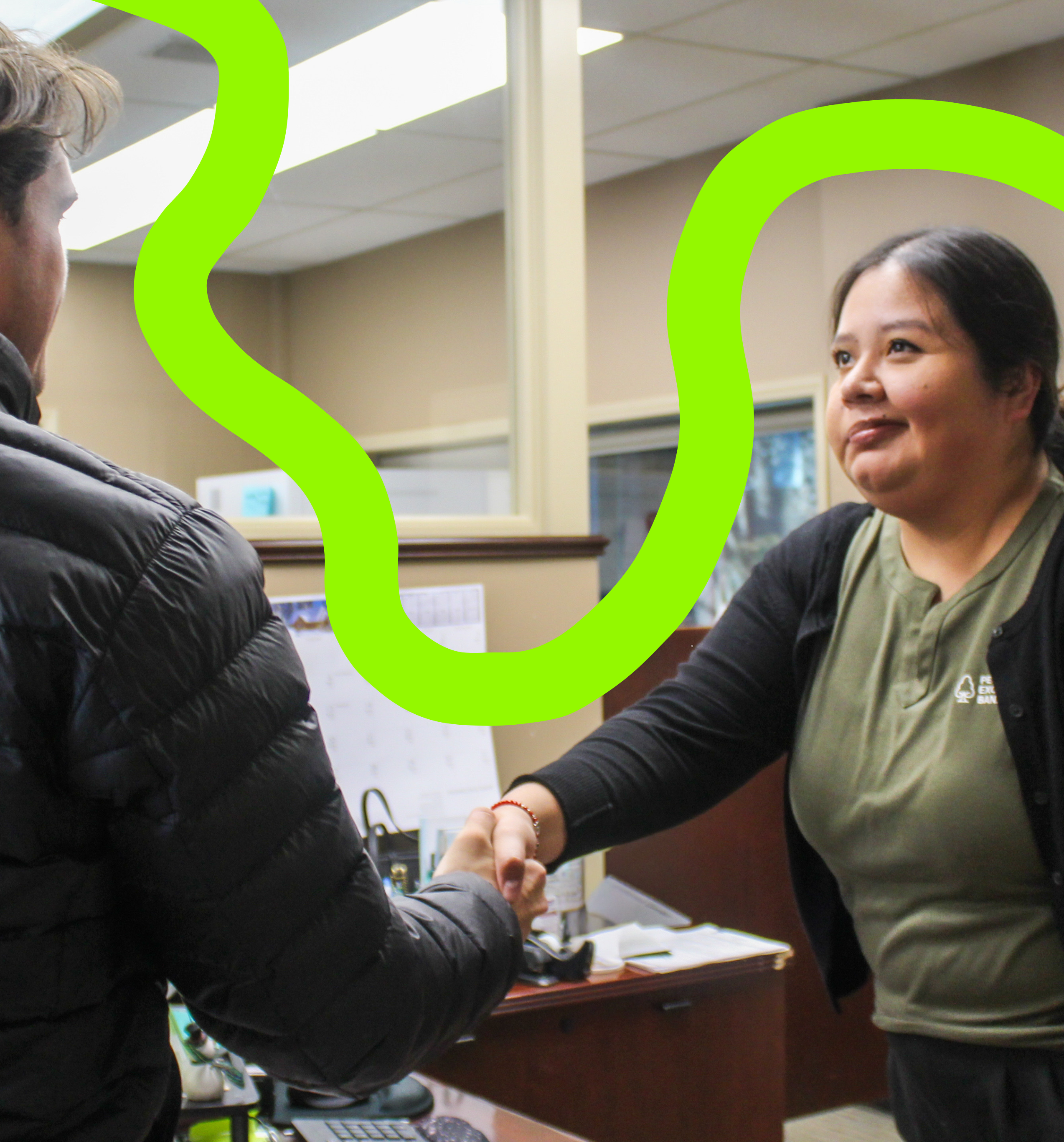 PEB employee smiling while shaking a customer's hand.